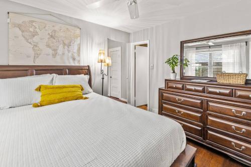 a bedroom with a bed and a dresser with a yellow pillow at Annesdale #1 - Spacious & Central 3BR in Midtown! in Memphis