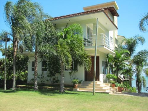 una casa con palmeras delante en Praia Recanto das Pedras, en Governador Celso Ramos