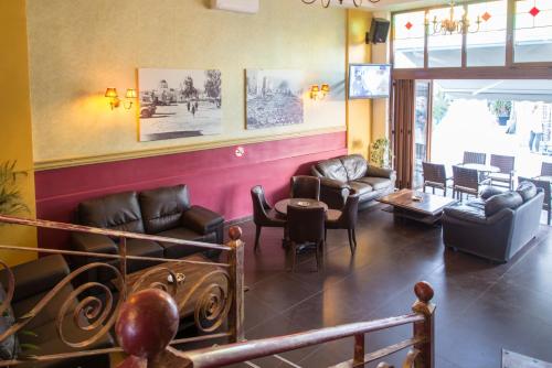 a waiting room with couches and a table and chairs at Rio Hotel in Kardamaina
