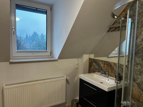 a bathroom with a sink and a window at Willa na Plażowej in Węgierska Górka