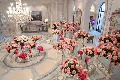 a room filled with vases filled with pink flowers at Four Seasons Hotel George V Paris in Paris