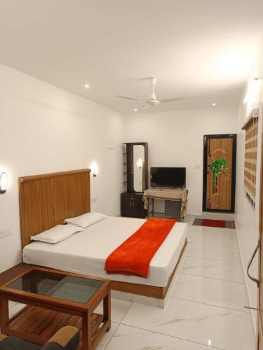 a bedroom with a large bed and a desk at Manjula Homestay in Vagamon