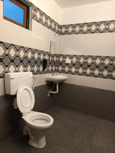 a bathroom with a toilet and a sink at Manjula Homestay in Vagamon