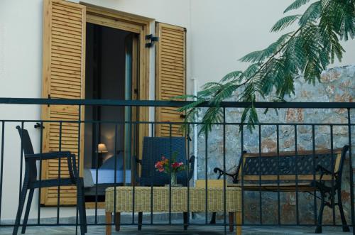 a balcony with two chairs and a table with flowers at Villa Sunrise in Epáno Kefalás