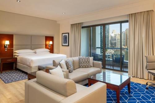 a bedroom with a bed and a living room at Sheraton The Walk, Dubai in Dubai