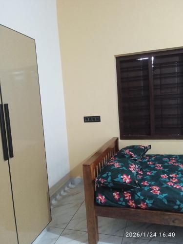 a bedroom with a bed and a window at Haven roots in Trivandrum