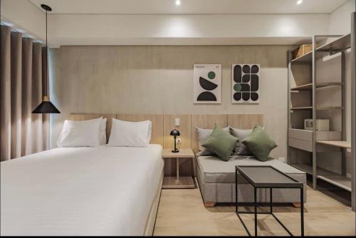 a bedroom with a large bed and a couch at Laureles Studios - Tomas in Medellín