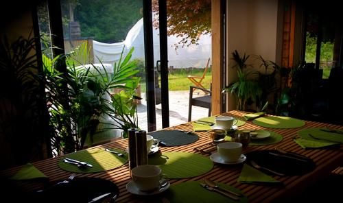 una mesa de madera con servilletas verdes y platos en ella en The Lodge Rooms en Coleford