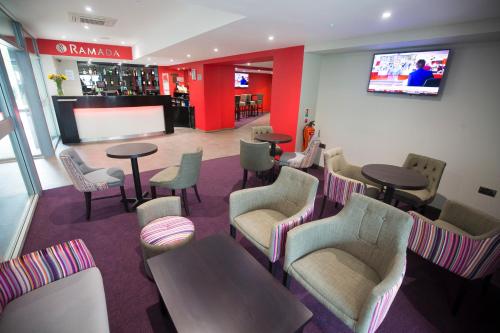 a living room filled with furniture and a tv at Ramada London South Mimms in Potters Bar