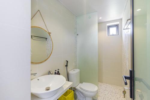 a bathroom with a sink and a toilet and a mirror at Cocohamlet Villa in Thanh Ðông (1)