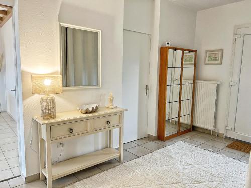 a room with a table with a lamp and a mirror at Horizon Lac - wifi - parking in Morges