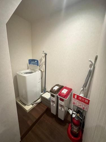 a small room with two trash cans and a machine at Small hidden wooden house in Osaka