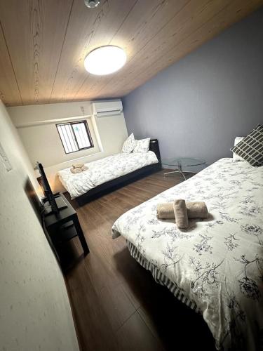 a bedroom with two beds in a room with a ceiling at Small hidden wooden house in Osaka
