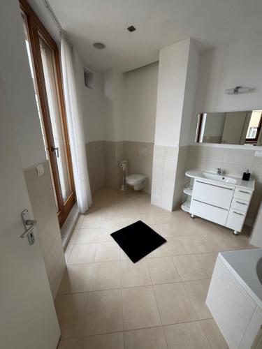 a white bathroom with a sink and a toilet at Central Walk Apartment in Bratislava