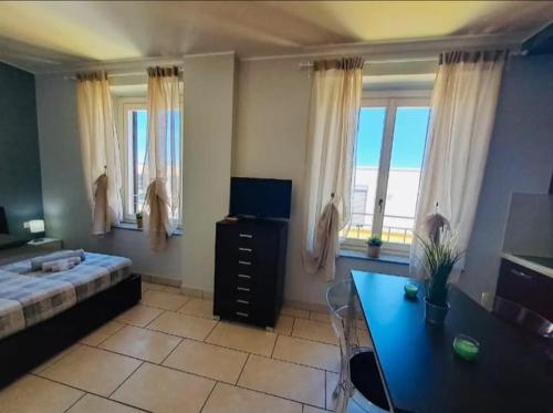 a bedroom with a bed and a desk and windows at Appartamento Valentina in Cremona