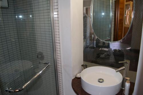 a bathroom with a sink and a glass shower at Roditses Beach Sea Front Apartments in Samos