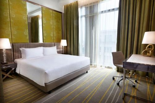 a hotel room with a bed and a desk and a computer at Dorsett Putrajaya in Putrajaya