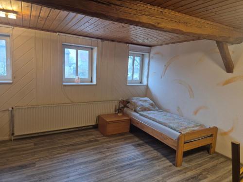 a small room with a bed and windows at Monteurwohnung in Frielendorf