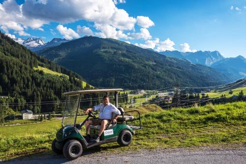 a man riding a golf cart on a mountain at Hotel CENTRAL Bar & Restaurant in Gerlos