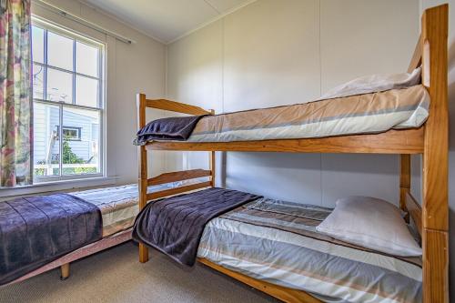 two bunk beds in a room with a window at Ohakune's Yellow Door in Ohakune