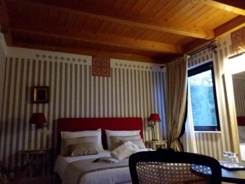 1 dormitorio con 1 cama con cabecero rojo y ventana en Country House Martines Club Resort & Mandalay SPA, en Senigallia