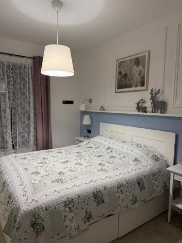 a bedroom with a bed with a white and blue comforter at Casa Elena in Banja Luka