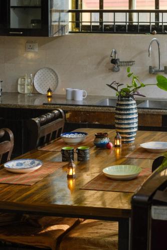 a wooden table in a kitchen with lights on it at Simsar Villa Homestay in Bahāsi