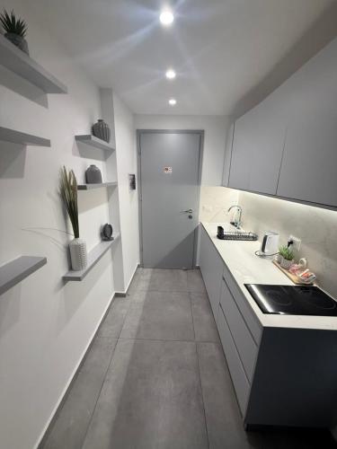 a white kitchen with a sink and a stove at חוויה בכיכר in Netanya