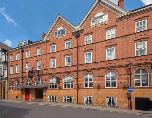 un grand bâtiment en briques rouges dans une rue dans l'établissement Macdonald New Blossoms Hotel, à Chester