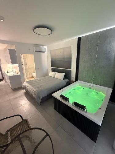 a bedroom with a bed and a green bath tub at חוויה בכיכר in Netanya