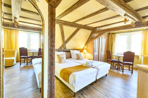 a bedroom with a bed and a table and chairs at Logis Hotel Saint-Martin in Colmar