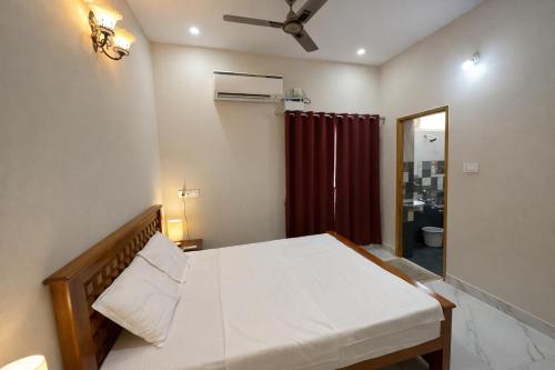 a bedroom with a bed and a red curtain at Sri Apartment Homestay 2BHK Pondicherry A1 in Pondicherry