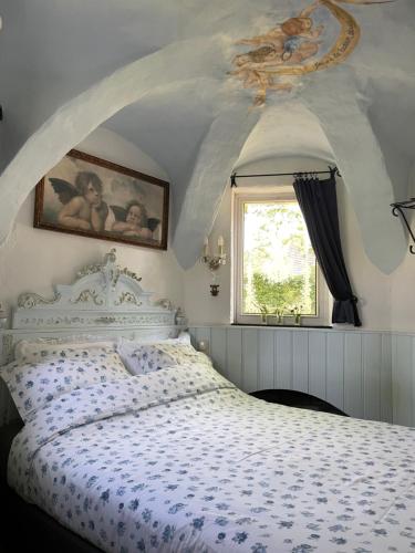 a bedroom with a bed with a blue and white comforter at Petit Château luxe vakantiehuis, prive hottub en zwembad in Heythuysen