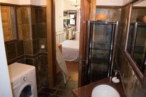 a bathroom with a washer and dryer in a room at Roditses Beach Sea Front Apartments in Samos