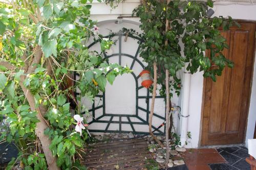 an entrance to a garden with a gate and trees at Roditses Beach Sea Front Apartments in Samos