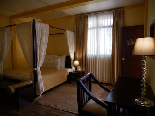 a bedroom with a bed and a table and a window at Sala Boutique Hotel in Male City