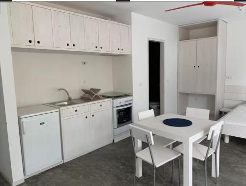 eine Küche mit weißen Schränken, einem Tisch und Stühlen in der Unterkunft Modern&Central Mindelo - 2A in Mindelo