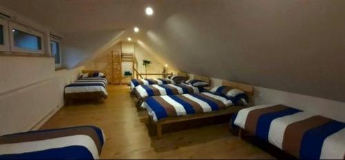 a room with eleven beds with blue and white stripes at Apartmány v Bývalém mlýně in Rokytnice v Orlických Horách