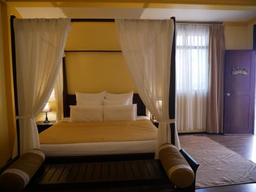 a bedroom with a canopy bed and a window at Sala Boutique Hotel in Male City