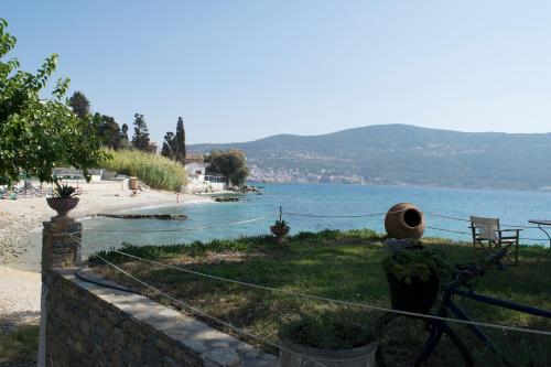 a beach with a fence and a body of water at Roditses Beach Sea Front Apartments in Samos