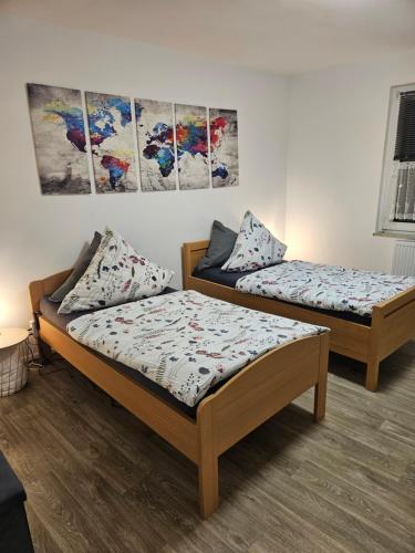two beds in a room with paintings on the wall at Appartement in Gelsenkirchen in Gelsenkirchen