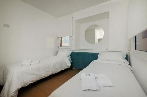 two beds in a small room with a mirror at Meca Playa in Villa Gesell