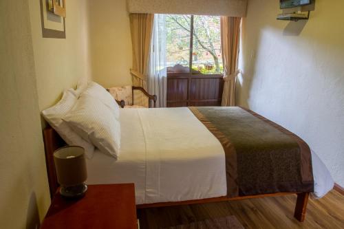 a bedroom with a bed with a window and a table at Casa Lloret in Cuenca