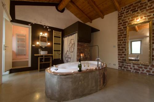 ein großes Bad mit einer großen Badewanne in der Mitte des Zimmers in der Unterkunft Il Riposo in San Damiano dʼAsti