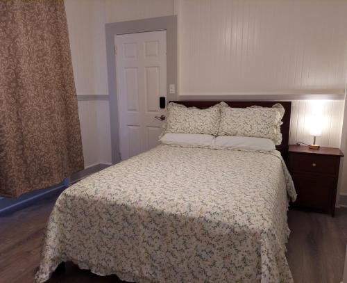 a bedroom with a bed with a white comforter and two lamps at Kekuanaoa Homestead for Double bedroom in Hilo