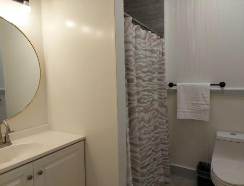 a bathroom with a toilet and a shower curtain at Kekuanaoa Homestead for Double bedroom in Hilo