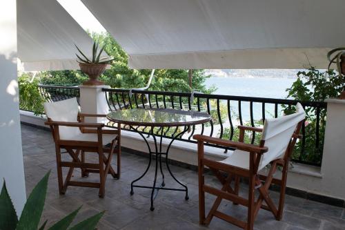 a patio with a table and chairs on a balcony at Roditses Beach Sea Front Apartments in Samos