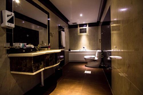 a bathroom with a sink and a toilet and a tub at Rest Night Serviced Apartments- AlHamra in Riyadh