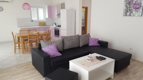 a living room with a black couch and purple pillows at Apartment Marta in Podgora