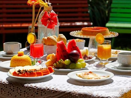una mesa cubierta con platos de comida y fruta en Pousada Casamar, en Porto de Galinhas
